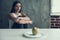 Woman Sitting on Chair with One Apple on Plate.