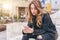 Woman sitting on city street, typing message, chatting on smartphone