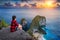 Woman sitting on cliff and looking at sunset at Kelingking Beach in Nusa penida island, Bali, Indonesia