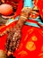 A woman sitting on the cot and mehndi applied on her hand in her marriage time.