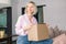 Woman sitting on couch at home opening carton box received parcel package