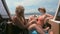 Woman sitting on deck of motorboat traveling around tropical island across ocean. Female person relaxing on ferry boat