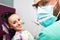 Woman sitting in dental chair while doctor examining her teeth