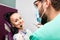 Woman sitting in dental chair while doctor examining her teeth