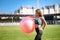 Woman sitting on fitball. Young and sportive woman training outdoors