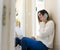 Woman sitting on the floor while teleworking from home and smiling while talking on the phone. Covid-19 work