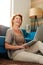 Woman sitting on floor typing on laptop laughing