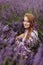 Woman Sitting in Full Bloom Lavender Field