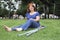 Woman sitting on the grass with a bandaged foot and crutches at her side