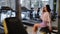 Woman sitting in gym, talking on phone, enjoying leisure time.