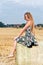 Woman sitting on hay bale