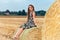 Woman sitting on hay bale