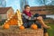 Woman sitting on haystack with pumpkin in front of