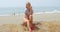 Woman Sitting on her Skateboard at the Beach