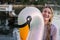 Woman sitting on inflatable swan toy