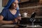 A woman is sitting in the kitchen and doing a beauty procedure using a beauty gadget