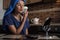 A woman is sitting in the kitchen and doing a beauty procedure using a beauty gadget