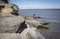 Woman sitting on a large boulder next to the lake