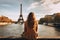 Woman Sitting Ledge, Looking Eiffel Tower, Paris, France, Young traveler woman rear view sitting on the quay of Seine River