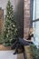 Woman sitting in loft grunge interior, christmas tree behind her