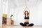 Woman sitting and looking up with hands up. Meditating doing breathing yoga bandhas. Health and wellness. Low angle view