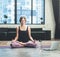 Woman Sitting in Lotus Pose. She is Calm, relaxed and happy outside the window bustling metropolis. Yoga Female