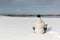 The woman sitting in a lotus pose on the snow riverbank