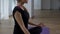 Woman sitting in meditation lotus pose in yoga gym