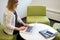 Woman sitting in modern workspace typing on laptop computer