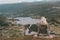 Woman sitting on a mountains peak while looking in a huge valley in norway