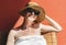 Woman sitting n smiling isolated on orange wall