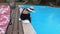 Woman sitting near swimming pool and touch the water