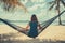 Woman sitting oin hammock on tropical beach