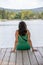 Woman sitting on a pier in front of lake Orfu , in Hungary