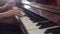 Woman is sitting and playing classical piano, closeup of hands and keys, side view. Concept of playing musical