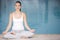 Woman sitting poolside doing yoga