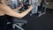 Woman sitting in profile training chest, arms muscles indoors