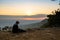 Woman sitting reading and writing looking out at natural view