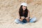 Woman sitting sand reading book