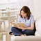 Woman sitting on sofa enjoying reading book