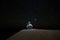 A woman sitting staring at the starry sky towards Venus, on a dune in the Erg Chebbi desert