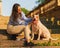 Woman sitting on stone staircase at dawn and petting happy american pitbull terrier