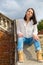 Woman sitting on stone staircase railing