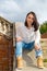 Woman sitting on stone staircase railing