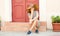 Woman sitting on strairs next to the bright red door