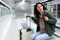 Woman sitting in subway station and waiting for train arrival