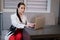 woman sitting by the table on couch in grey room - office and use laptop. big boss. important, confident women