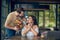 Woman sitting at table and standing man with bouquet