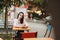 Woman sitting at a table on the street. Evening warm city.