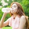 Woman sitting tired and drinking water after exercise.